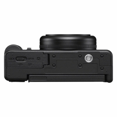 Câmara fotográfica compacta preta vista de baixo com controles e textura rugosa