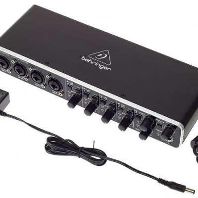 Interface de áudio Behringer preta com entradas XLR/TRS e botões de volume