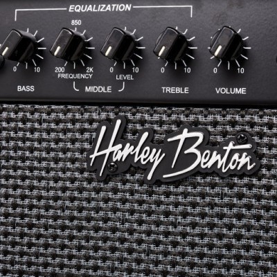 Painel de amplificador Harley Benton preto com botões rotativos e textura cinza preta na parte inferior.