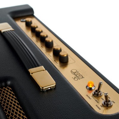 Amplificador de guitarra preto com painel dourado e botões pretos