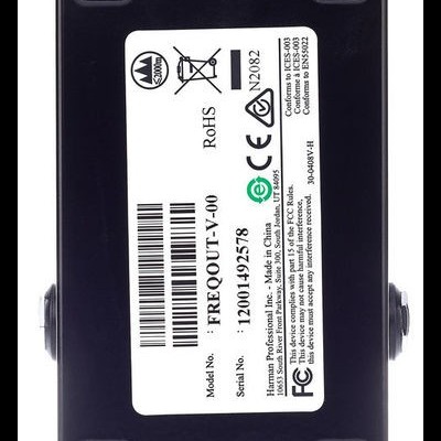 Equipamento eletrônico preto com etiqueta branca e códigos de barras na superfície plana