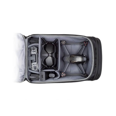 Mochila aberta com drone, comando e óculos escuros