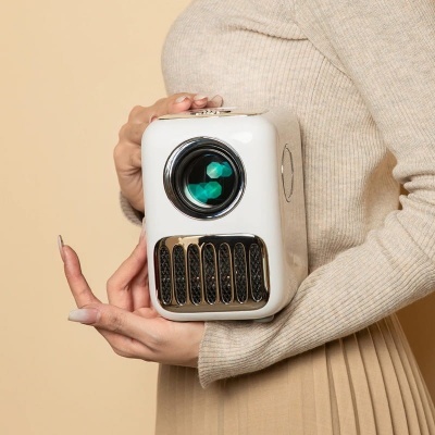 Pessoa a segurar uma câmara branca com lente preta e detalhes dourados, vestida com roupa bege