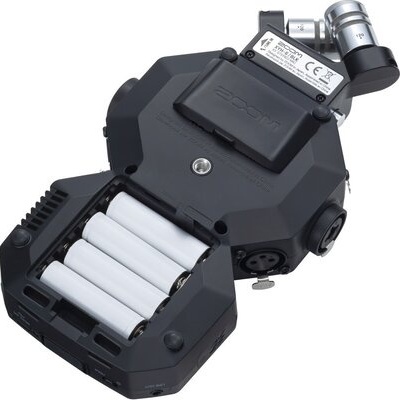 Dispositivo eletrônico preto com pilhas visíveis e conector metálico