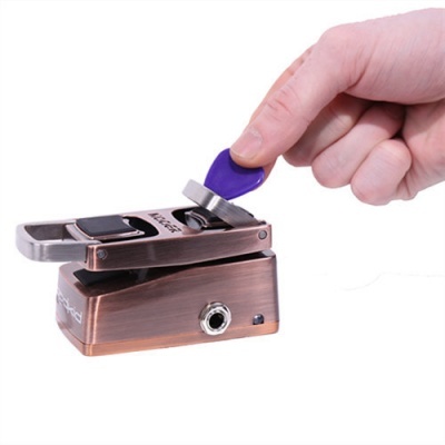 Pedal de efeito para guitarra cor cobre metal com palheta roxa inserida