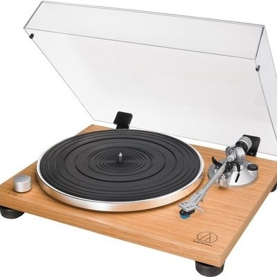 Gira-discos com base em madeira clara e tampa transparente levantada