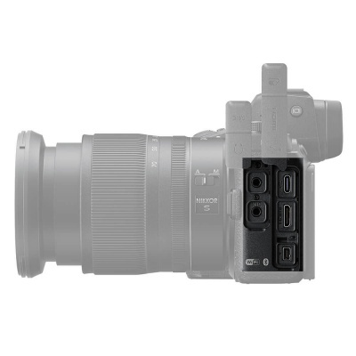 Máquina fotográfica digital cinzenta com lente NIKKOR S e portas de ligação visíveis