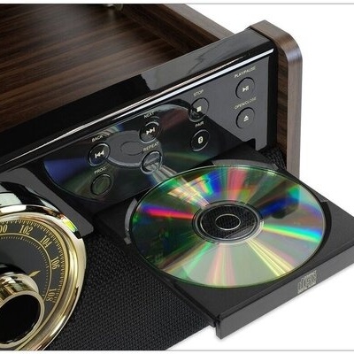 Aparelhagem de som com acabamento em madeira, botão analógico dourado, e bandeja de CD aberta com disco colocado