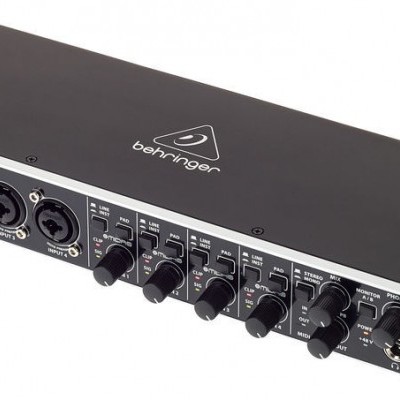 Interface de áudio Behringer preta com botões e entradas frontais