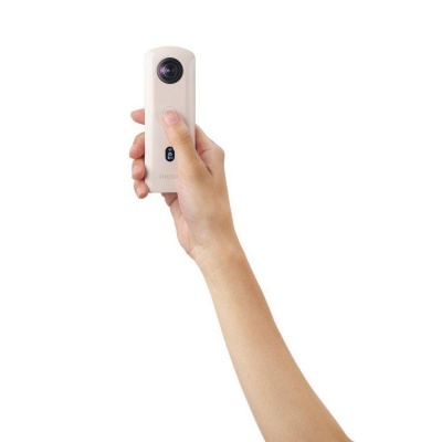 câmara compacta portátil branca com lente esférica numa mão