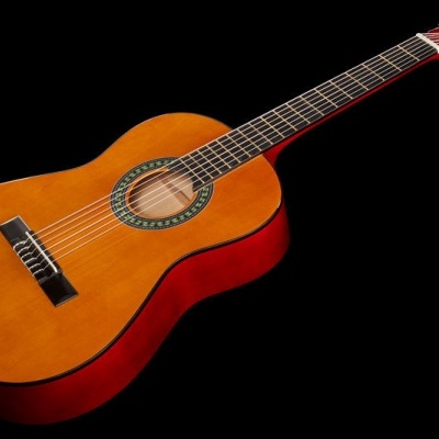 Guitarra clássica de madeira com tampo alaranjado e laterais vermelhas sobre fundo preto