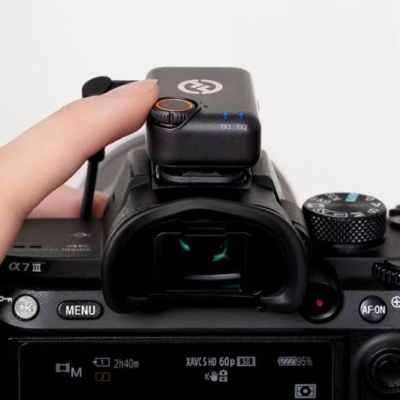 Parte traseira de câmara digital preta com botões e acessório com logótipo CG