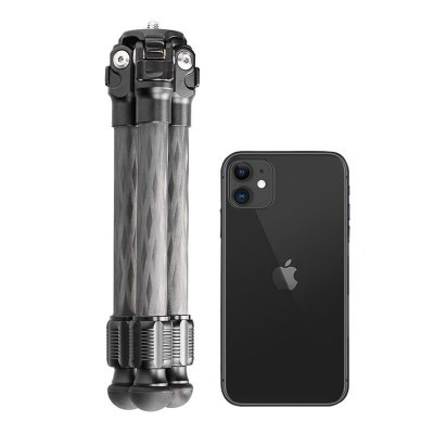Mini tripé metálico preto ao lado de smartphone Apple preto sobre fundo branco