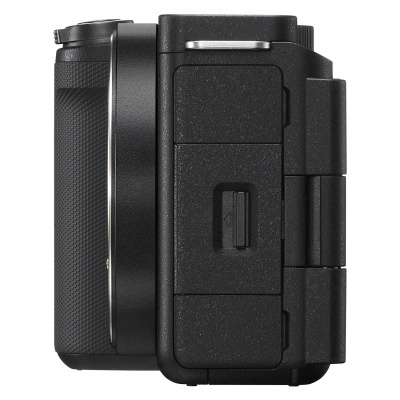 Máquina fotográfica digital compacta preta vista lateral com compartimentos e textura rugosa