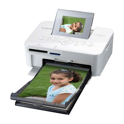 Impressora fotográfica Canon SELPHY branca em funcionamento com foto de criança a sair