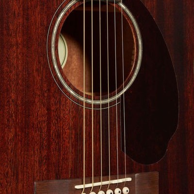 Guitarra acústica castanha com seis cordas e detalhes brancos na boca