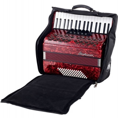 Acordeão vermelho marmoreado com botões e teclado piano dentro de bolsa preta aberta