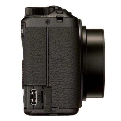 Câmara fotográfica preta vista de lado com lente projetada e porta USB