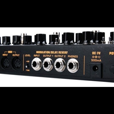 Equipamento eletrónico preto com múltiplas entradas e saídas e etiquetas brancas