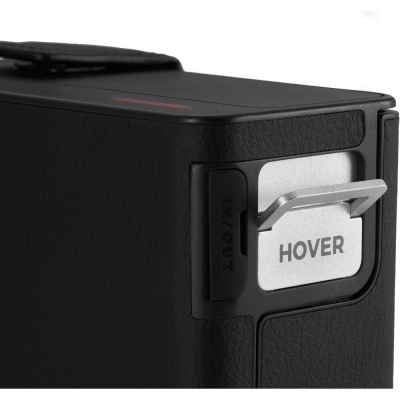 Dispositivo preto com botão metálico etiquetado HOVER