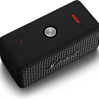 Coluna portátil preta com grelha metálica frontal e botão prateado no topo