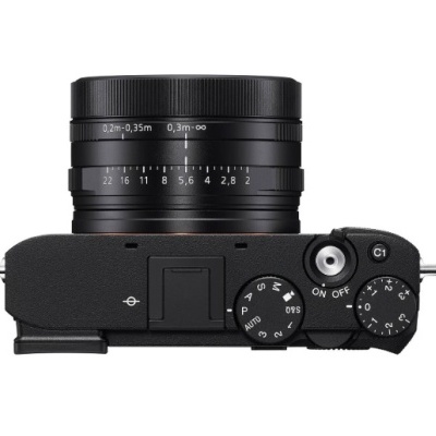 Câmara fotográfica preta vista de cima com lentes e controlos visíveis