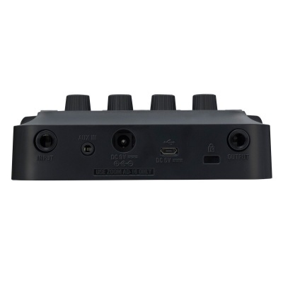 Dispositivo eletrónico preto com botões e entradas/saídas marcadas, visto de trás