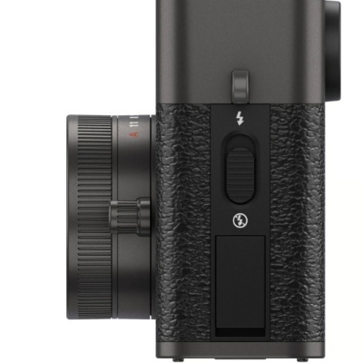 Máquina fotográfica compacta preta com lente ajustável, textura no corpo e símbolos de flash