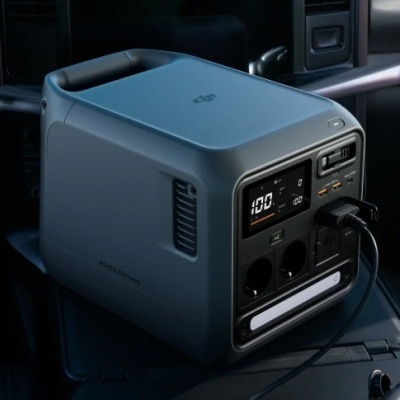 Powerbank portátil DJI PowerOasis Mini cinza escuro com ecrã digital e várias portas de saída num veículo