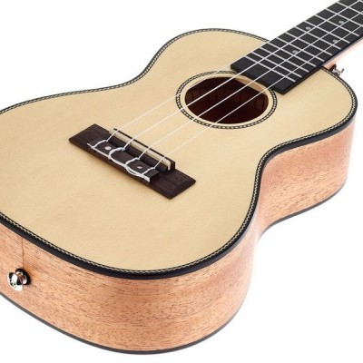 Ukulele acústico de madeira clara com cordas brancas e fingerboard escuro