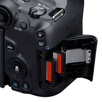 Câmara fotográfica profissional preta com porta do compartimento de cartões de memória aberta