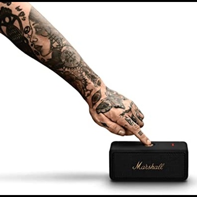 Coluna portátil Marshall preta com botão vermelho e mão tatuada