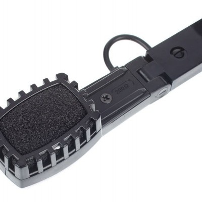 Dispositivo preto com superfície acolchoada e cabo, fundo branco.