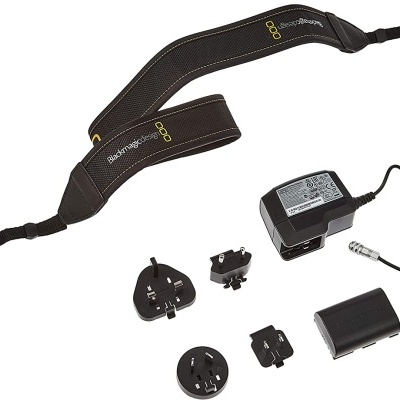acessórios fotográficos incluindo correia preta, bateria, adaptador de corrente e adaptadores de tomadas
