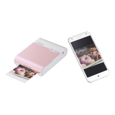 Impressora portátil rosa claro imprimindo foto ao lado de smartphone branco com foto na tela