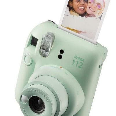 Câmara instantânea verde claro Fujifilm Instax Mini 12 com fotografia saída de duas pessoas com óculos de sol