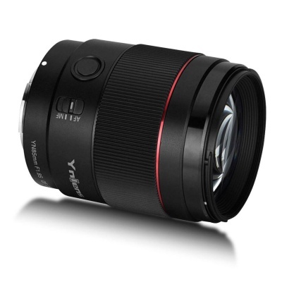 Objetiva fotográfica preta com anel vermelho sobre fundo branco