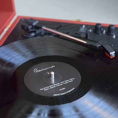 Gira-discos vintage vermelho a tocar um disco de vinil preto