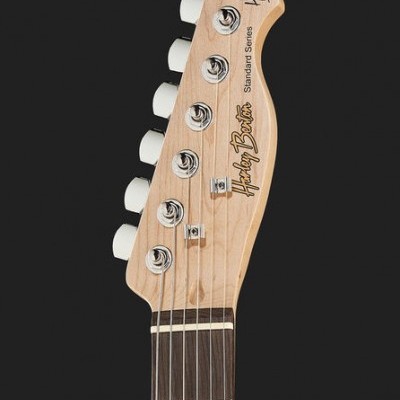 Cabeça de guitarra elétrica em madeira clara com cravelhas brancas.