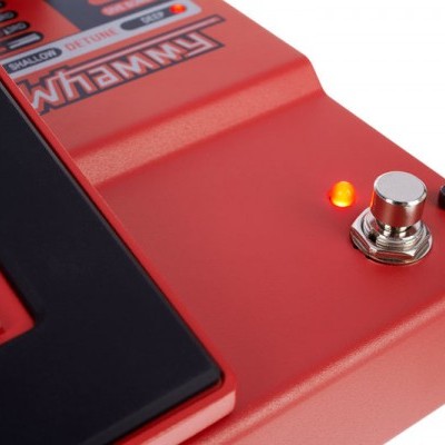 Pedal de efeito vermelho para guitarra com botão prateado e luz LED acesa