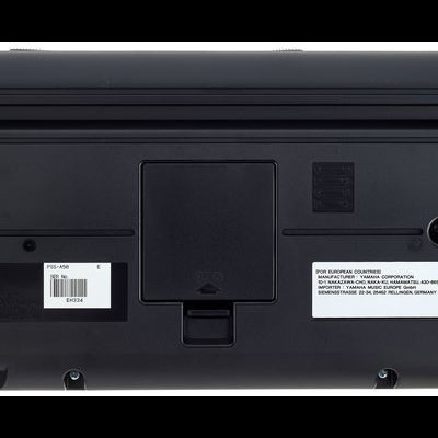 Parte inferior de calculadora eletrónica preta com etiquetas e compartimento de bateria