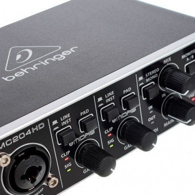 Interface de áudio Behringer preta com botões de controlo e entradas de áudio