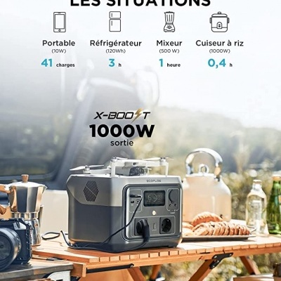 Gerador portátil X-BOOST 1000W cinza sobre mesa de madeira ao ar livre com acessórios de cozinha