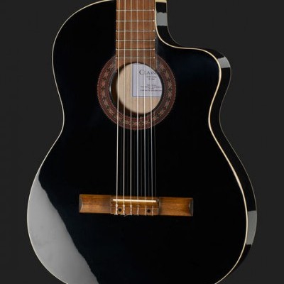 Guitarra clássica preta com braço castanho e etiquetas visíveis