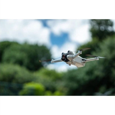 Drone branco com quatro hélices em voo ao ar livre