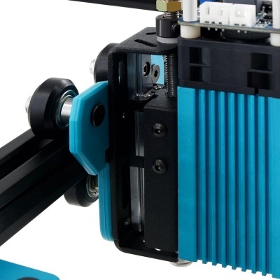 Detalhe de equipamento preto e azul turquesa com componentes metálicos e plásticos