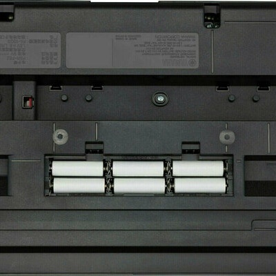 Parte inferior de portátil preto com compartimento de pilhas AA visíveis