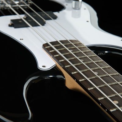 Guitarra elétrica preta com escudo branco e cordas metálicas