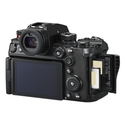 Câmara fotográfica digital preta vista de trás com ecrã LCD e compartimento para cartões aberto