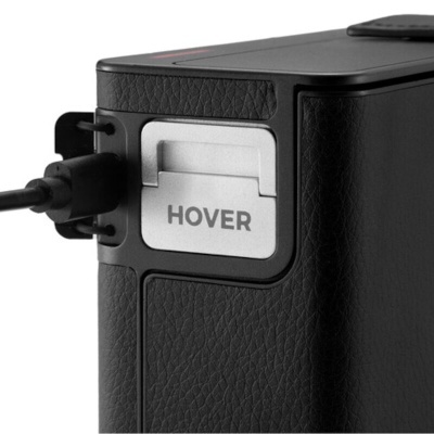 Equipamento eletrônico preto com textura couro e tampa metálica com texto HOVER